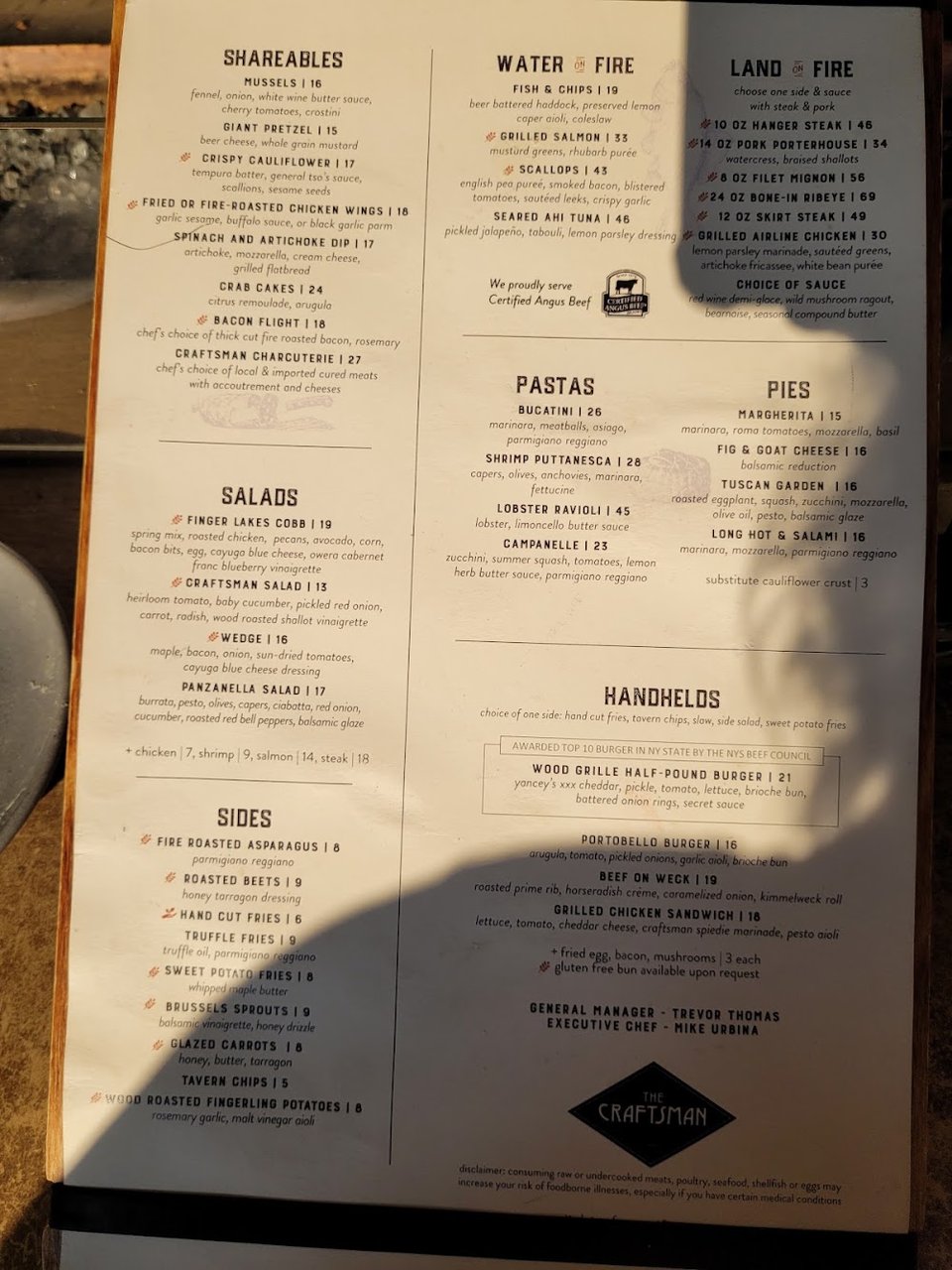 Plated burgers beside a glass of craft beer.